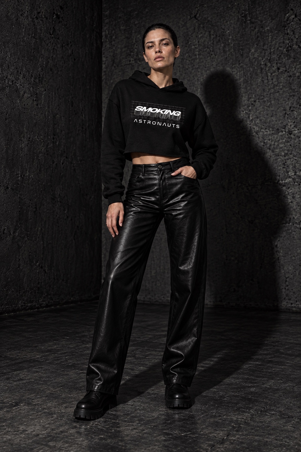 AI styling concept: adult woman in a black Cosmic Grid cropped hoodie, long black leather trousers and chunky boots